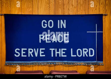 `Go in Peace Serve the Lord` written on Dark Blue Cloth with white cross on the right side, tassels all along the bottom of the cloth. Stock Vector